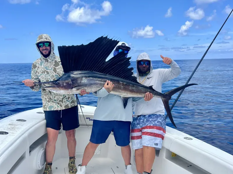Angler holding a large sailfish aboard Silent Hunter